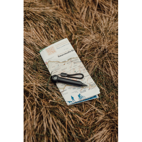 Crayon infini posé sur une carte en extérieur, sans marquage visible.