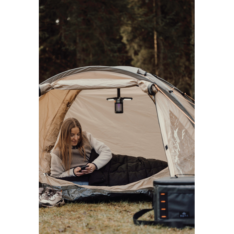 Couverture utilisée dans une tente avec une personne allongée dessous, sans personnalisation visible.