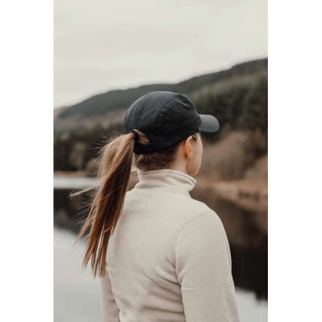 Casquette noire portée par une femme vue de dos en extérieur, sans personnalisation visible.