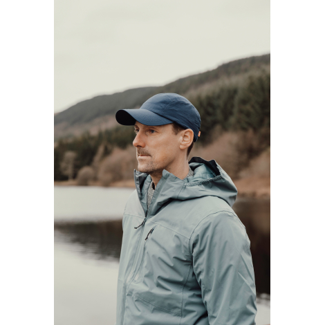 Casquette bleue portée par un homme en extérieur, sans personnalisation visible.