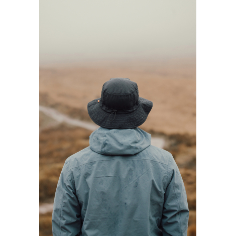 Bob noir porté par une personne vue de dos en extérieur, sans marquage visible.