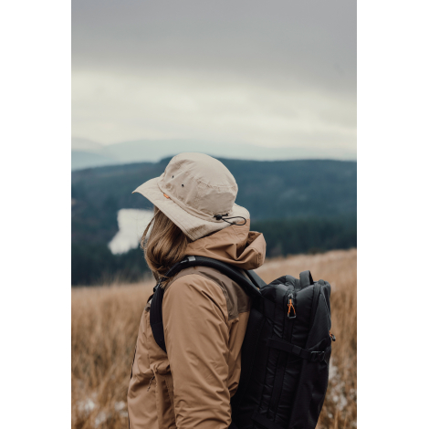 Bob beige porté de profil par une personne avec sac à dos en extérieur, sans personnalisation visible.