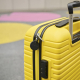 Balise de suivi noire attachée à une valise en situation, sans marquage apparent. Balise de suivi noire attachée à une valise en situation, sans marquage apparent.
