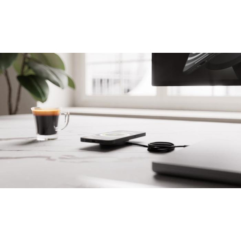 Chargeur sans fil utilisé sur un bureau avec smartphone en situation, sans marquage visible sur les zones observables.