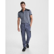 Pantalon de travail gris avec détails noirs porté par un homme en situation, sans marquage visible. Pantalon de travail gris avec détails noirs porté par un homme en situation, sans marquage visible.