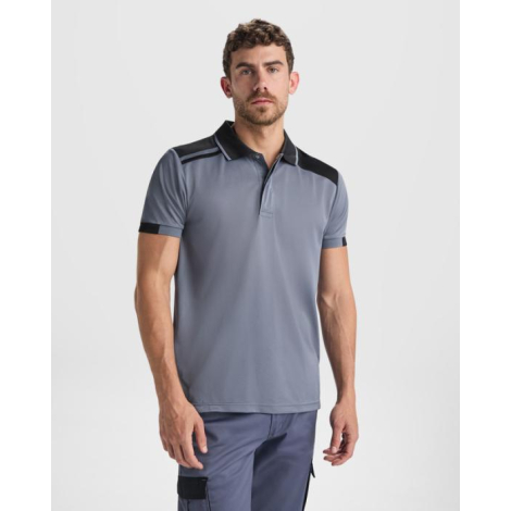 Homme portant un polo unisexe gris à manches courtes avec empiècements noirs aux épaules, présenté de face sans marquage visible
