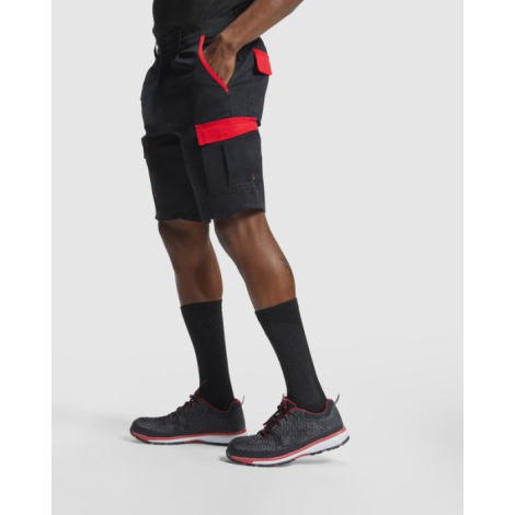 Homme portant un short de travail noir avec détails rouges et poches cargo latérales, présenté de profil sans personnalisation a