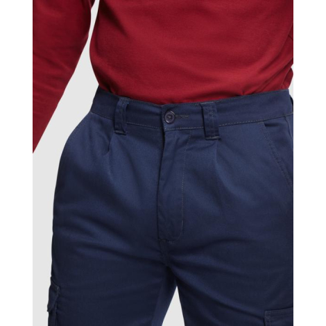 Zoom sur la taille d’un pantalon de travail bleu marine mettant en avant la fermeture boutonnée, les passants de ceinture et les