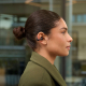 Femme portant des écouteurs sans fil noirs à oreille ouverte illustrés en situation d’utilisation, sans personnalisation visible Femme portant des écouteurs sans fil noirs à oreille ouverte illustrés en situation d’utilisation, sans personnalisation visible