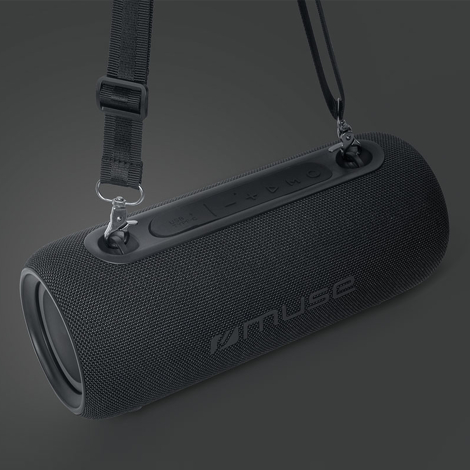 Enceinte Bluetooth noire suspendue par sa sangle de transport, sans marquage apparent sur la structure cylindrique.