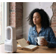 Femme utilisant un ventilateur sans pales posé sur une table à côté d’un livre et d’une tasse, sans personnalisation visible. Femme utilisant un ventilateur sans pales posé sur une table à côté d’un livre et d’une tasse, sans personnalisation visible.