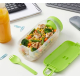 Boîte à lunch remplie de nourriture dans un environnement de bureau avec couvercle ouvert et cuillère-fourchette posée à côté, s Boîte à lunch remplie de nourriture dans un environnement de bureau avec couvercle ouvert et cuillère-fourchette posée à côté, s