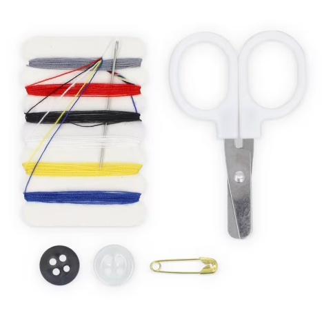 Contenu du kit présenté à plat avec fils multicolores, aiguille, ciseaux, bouton, bouton pression et épingle de sûreté.
