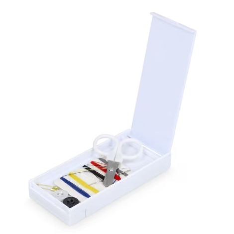 Vue d’une boîte ouverte présentant les accessoires de couture rangés à l’intérieur.