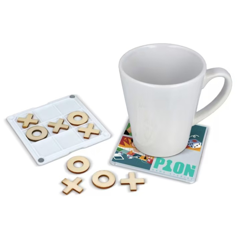 Sous-verre utilisé sous une tasse tandis que le plateau de jeu et plusieurs pièces en bois sont disposés à côté.