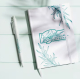 Carnet A5 présenté en situation d’utilisation avec marquage visible sur la couverture avant, posé à côté d’un stylo assorti.