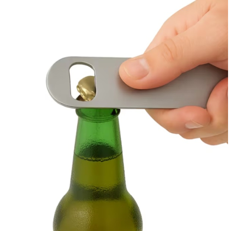 Ouvre-bouteille en acier inoxydable utilisé pour retirer la capsule d’une bouteille, montré en situation au contact du goulot.