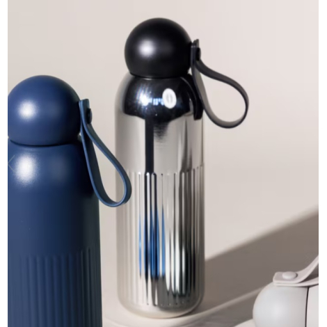 Mise en situation présentant deux bouteilles de la gamme, un modèle chromé et un modèle bleu avec dragonne de transport, sans pe
