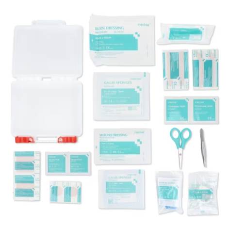 Boîte de premiers secours ouverte accompagnée de ses 37 accessoires de soin disposés à plat pour présenter le contenu complet du