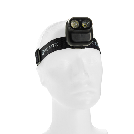 Lampe frontale portée sur un bandeau élastique noir, avec marquage apparent sur la face avant du boîtier.