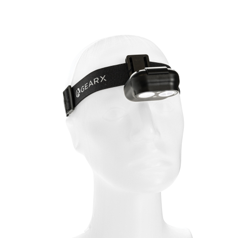 Vue de trois quarts de la lampe frontale montée sur son bandeau réglable, présentant une personnalisation visible sur la face av