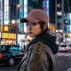Femme portant la casquette brun délavé dans une rue animée, sans personnalisation visible.