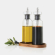 Ensemble huile et vinaigre composé de deux bouteilles en verre remplies respectivement d’huile et de vinaigre, présentées sur le Ensemble huile et vinaigre composé de deux bouteilles en verre remplies respectivement d’huile et de vinaigre, présentées sur le