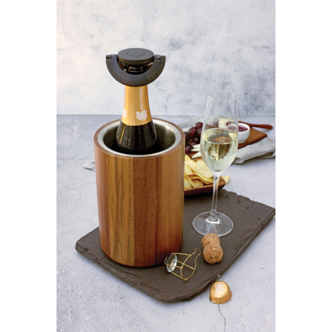 Bouchon à champagne utilisé sur une bouteille placée dans un rafraîchisseur en bois, avec une flûte de champagne, un bouchon de 