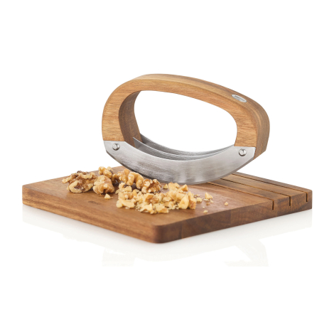 Ensemble hachoir avec planche présenté avec des cerneaux de noix déposés sur la planche.