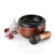 Ensemble mortier et pilon avec des herbes fraîches dans le mortier, accompagné d’une tête d’ail et de plusieurs gousses d’ail. L Ensemble mortier et pilon avec des herbes fraîches dans le mortier, accompagné d’une tête d’ail et de plusieurs gousses d’ail. L