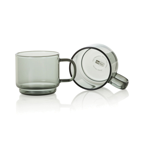 Deux tasses expresso en verre fumé avec anse, dont une vue de face et une vue inclinée montrant le dessous de la tasse. Aucune p
