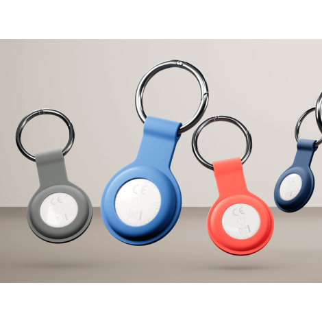 Trois traceurs connectés présentés de dos dans différents coloris, laissant apparaître leur anneau métallique d’attache et leur 