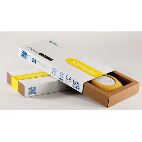 Traceur connecté jaune présenté dans son emballage, visible à travers une boîte ouverte en carton kraft.