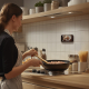 Femme dans une cuisine utilisant un smartphone fixé sur une surface sans personnalisation visible Femme dans une cuisine utilisant un smartphone fixé sur une surface sans personnalisation visible