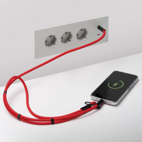 Tour de cou rouge avec câble de charge intégré relié à un smartphone et branché à une prise murale sans personnalisation visible