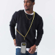 Homme portant un smartphone suspendu à un cordon bicolore jaune et noir en bandoulière sans personnalisation visible Homme portant un smartphone suspendu à un cordon bicolore jaune et noir en bandoulière sans personnalisation visible