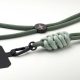 Gros plan sur un cordon vert avec nœud contrasté, mousqueton noir et plaque de fixation, accompagné d’un élément de réglage circ Gros plan sur un cordon vert avec nœud contrasté, mousqueton noir et plaque de fixation, accompagné d’un élément de réglage circ
