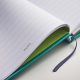 Gros plan sur des pages lignées personnalisées avec impression visible en bas de page et marque-page ruban Gros plan sur des pages lignées personnalisées avec impression visible en bas de page et marque-page ruban