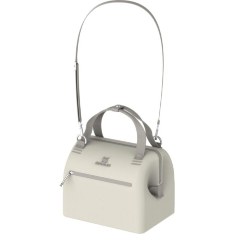 Vue rapprochée de la partie supérieure du sac montrant les poignées de transport, les attaches métalliques et la bandoulière amo