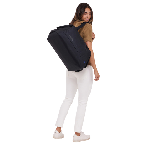Femme portant le sac de voyage sur le dos en configuration sac à dos, sans personnalisation visible.