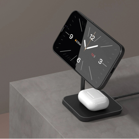 Chargeur de bureau en situation d'utilisation avec un smartphone fixé sur le support magnétique et des écouteurs sans fil posés 