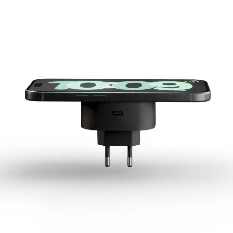 Adaptateur de charge sans fil utilisé avec un smartphone fixé sur la surface de charge magnétique, sans marquage visible.