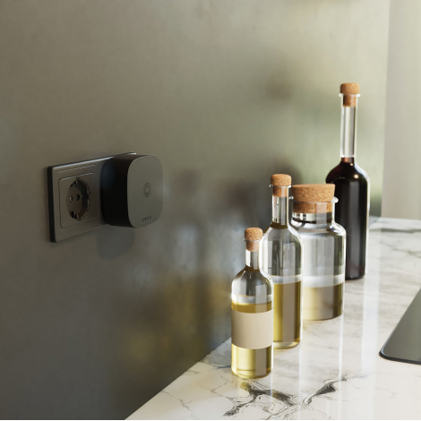 Adaptateur de charge sans fil branché sur une prise murale dans un environnement intérieur, utilisé avec un smartphone fixé sur 