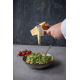 Personne utilisant la tranchette à fromage pour découper de fines lamelles au-dessus d’une salade, sans personnalisation visible Personne utilisant la tranchette à fromage pour découper de fines lamelles au-dessus d’une salade, sans personnalisation visible