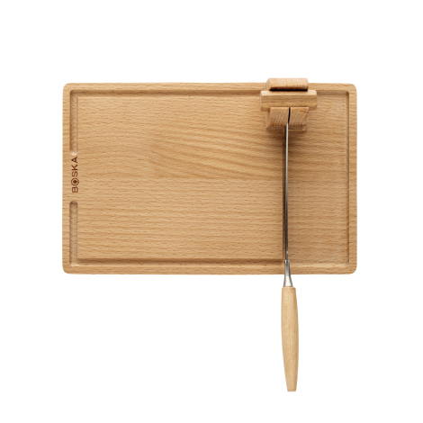 Vue de dessus d’une planche à découper en bois avec le coupe-fromage monté sur son support, sans marquage visible sur la planche