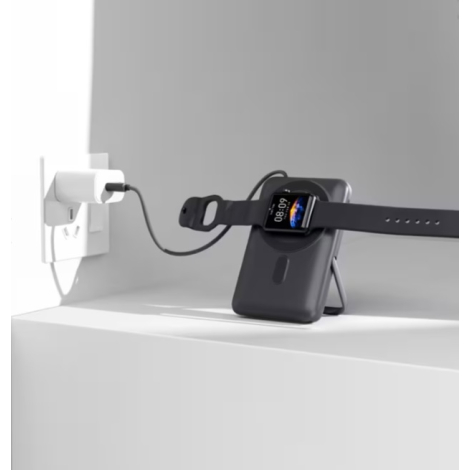 Batterie externe utilisée comme support pour recharger une montre connectée, reliée à une prise secteur.