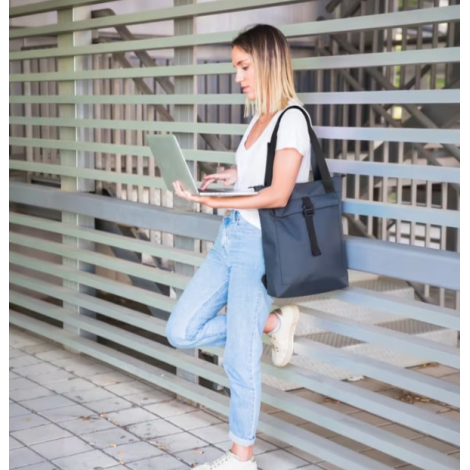 Femme portant le sac à dos bleu pour ordinateur portable à l'épaule.