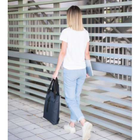 Femme transportant le sac à dos noir pour ordinateur portable à la main.
