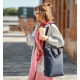 Femme portant le sac convertible à l'épaule en configuration sac à bandoulière. Femme portant le sac convertible à l'épaule en configuration sac à bandoulière.