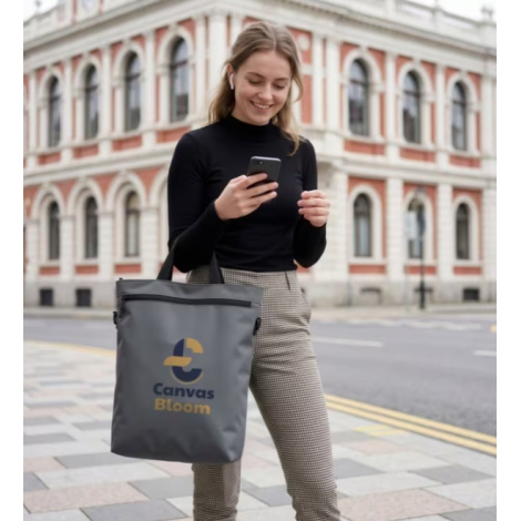 Femme portant le sac convertible à l'épaule en configuration sac à bandoulière avec une personnalisation visible sur la face ava